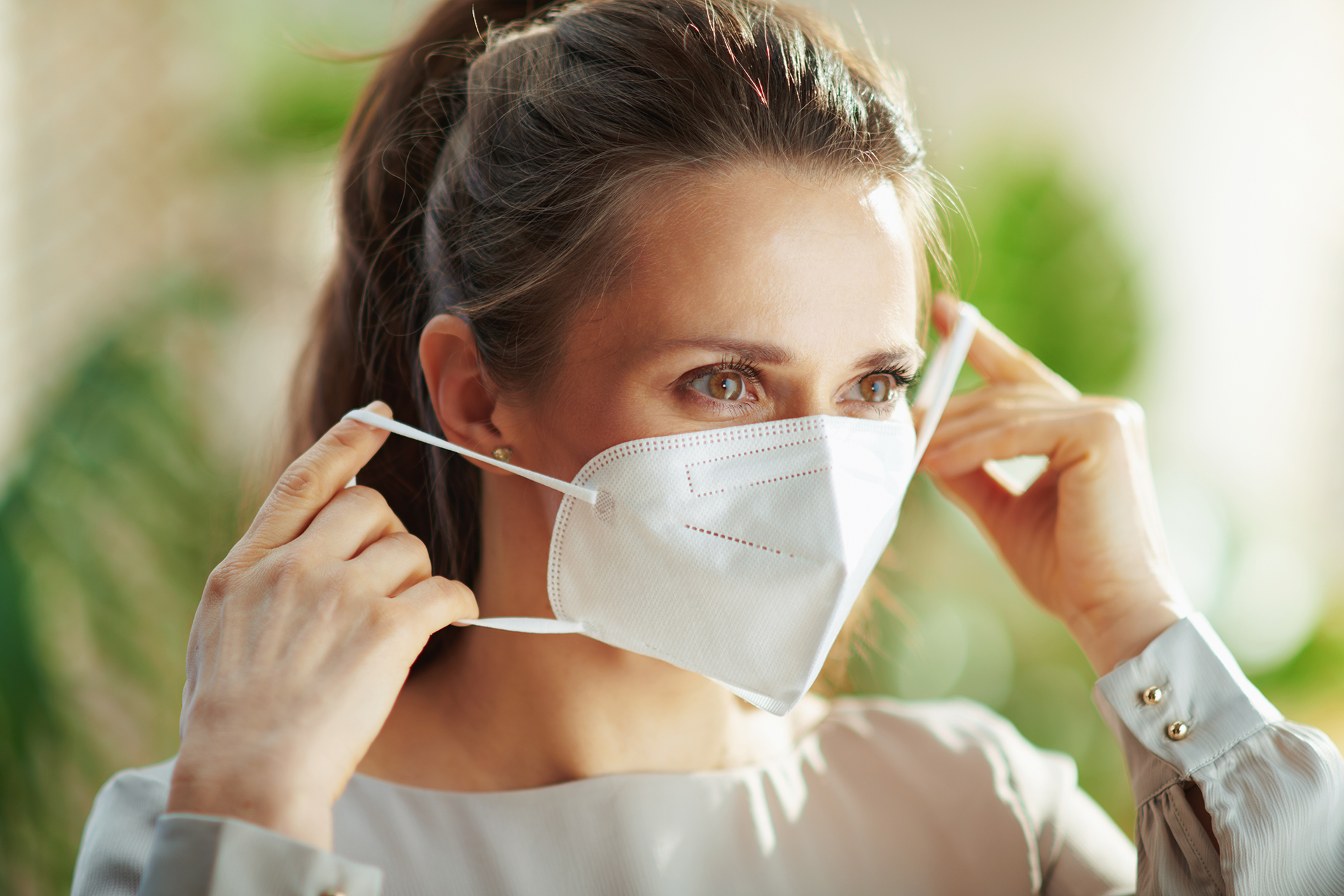 Woman in grey blouse wearing ffp mask Woman in grey blouse wearing ffp mask